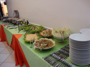 Mesa com buffet de pratos quentes e saladas